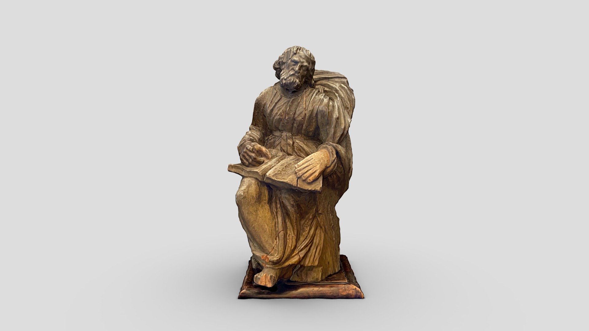 Wooden statue of a monk reading