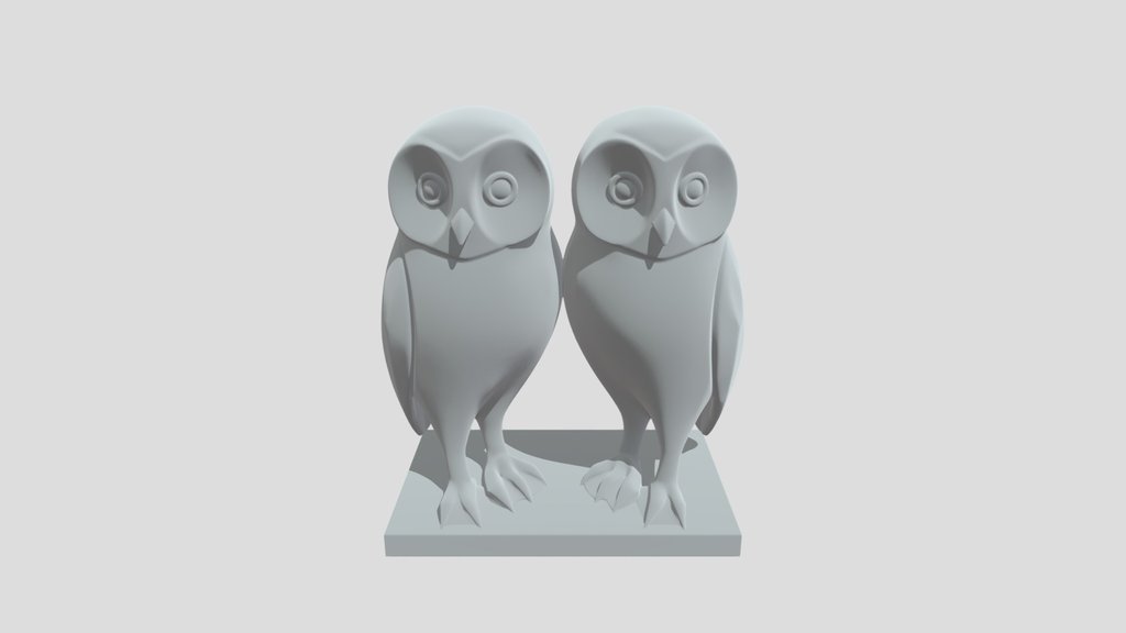 Une sculpture de couple de chouettes effraies