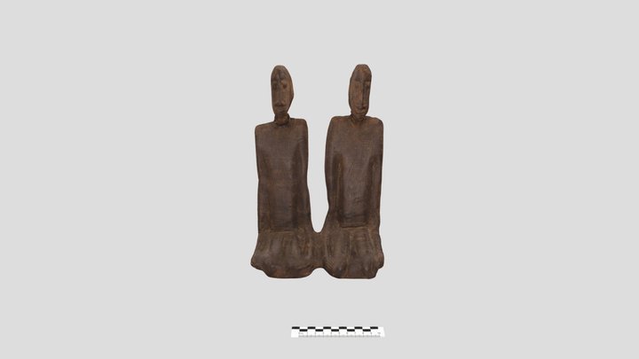 Drewniana, rzeźbiona figura prezentująca dwie, złączone postacie. Obydwoje znajdują się w pozycji siedzącej.