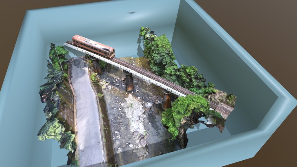 森の小川にかかる高架を走る電車