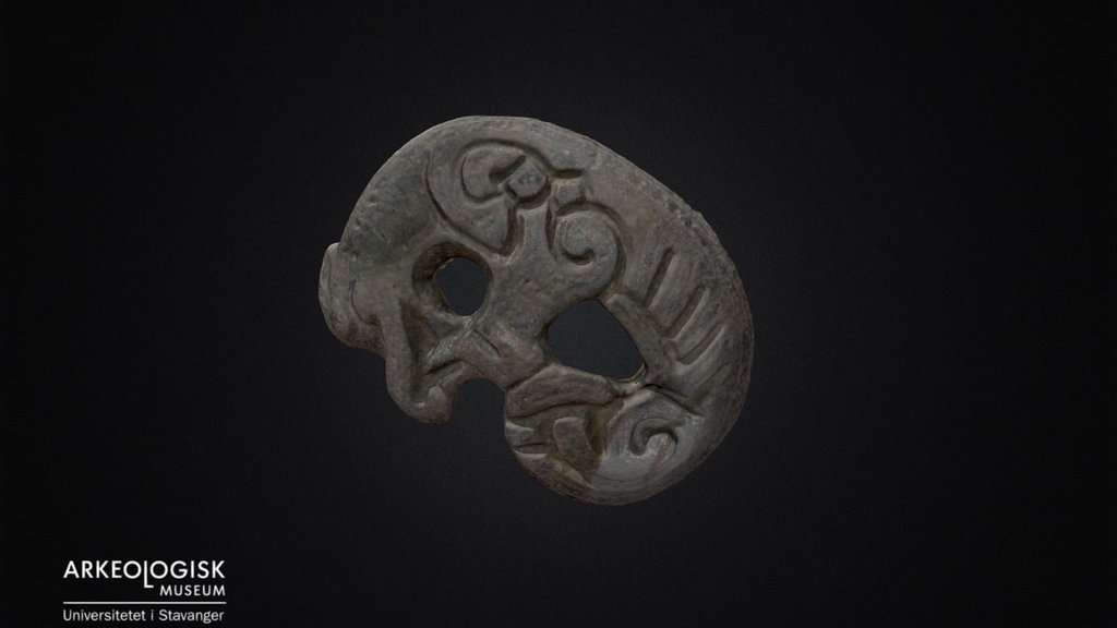 Silver pendant of coiled animal.