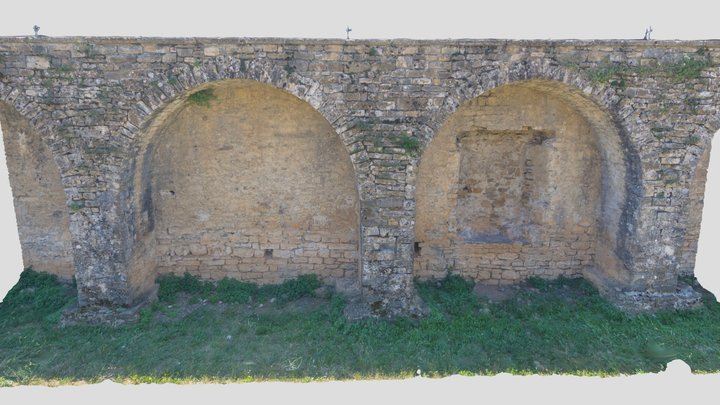 a stone wall with two arched windows